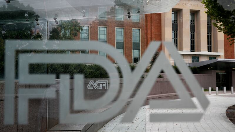 FILE - The U.S. Food and Drug Administration building stands behind an FDA logo at a bus stop...