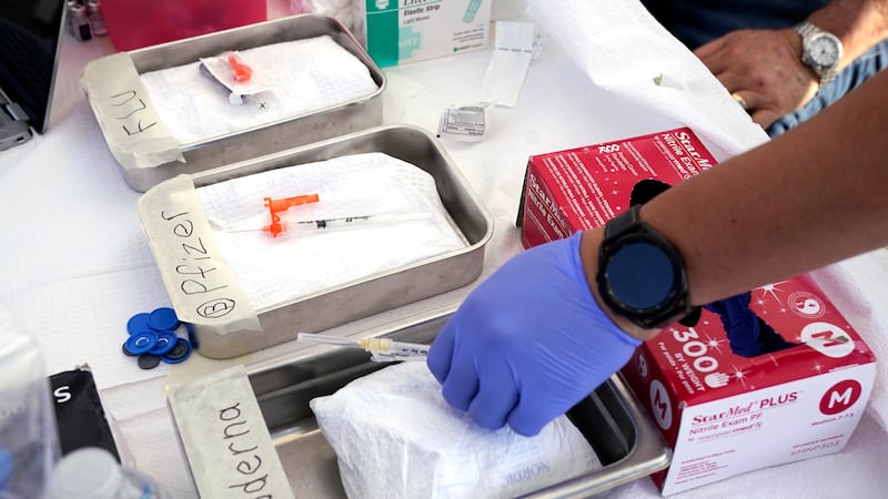 FILE - Syringes with vaccines are prepared at the L.A. Care and Blue Shield of California...