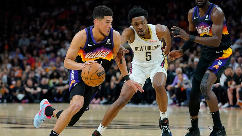 Phoenix Suns guard Devin Booker (1) drives as New Orleans Pelicans forward Herbert Jones (5)...
