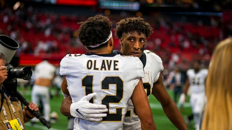 New Orleans Saints wide receiver Michael Thomas (13) embraces wide receiver Chris Olave (12)...