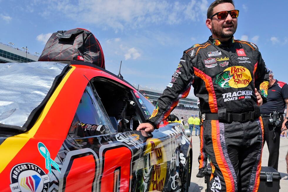 Martin Truex Jr. stands next to his car affixed with a sticker in memory of Sherry Pollex...
