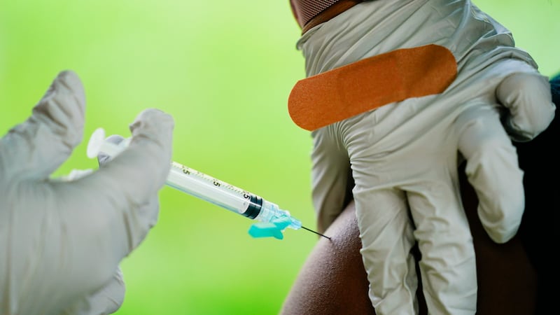 A health worker administers a dose of a Pfizer COVID-19 vaccine during a vaccination clinic in...