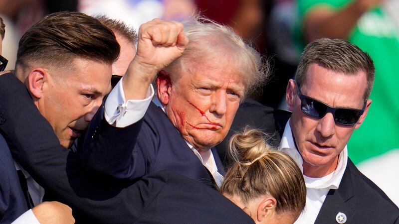 Republican presidential candidate former President Donald Trump is helped off the stage by...