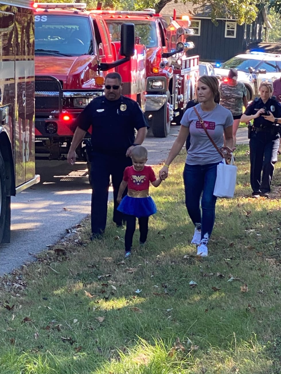 JoJo and her mom, Courtnee, walk alongside a parade of first responders, who returned their...