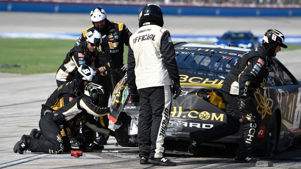 The pit crew works on Kyle Busch's car after he touched the wall during the NASCAR Cup Series...