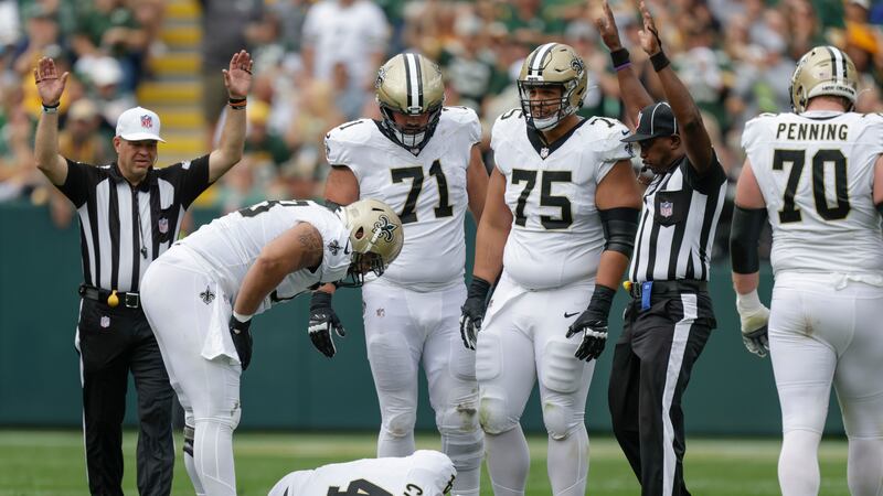 Saints quarterback Derek Carr (4) lays on the turf with a shoulder injury after being sacked...