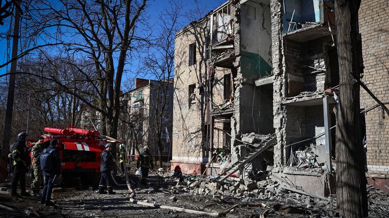 Ukrainian Emergency Service rescuers work on a building damaged by shelling in Kramatorsk,...