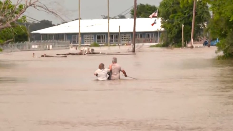 A couple walked through waist-high floodwaters Saturday, May 4, 2024, in Harris County, Texas....